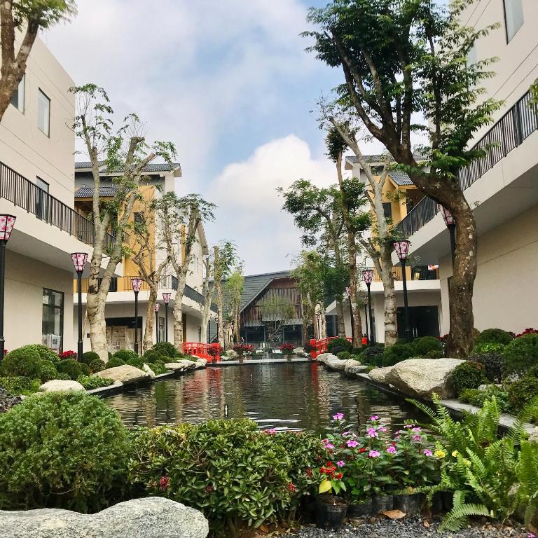 a canal in a courtyard with flowers and buildings at Wyndham Thanh Thủy in Chú Mật