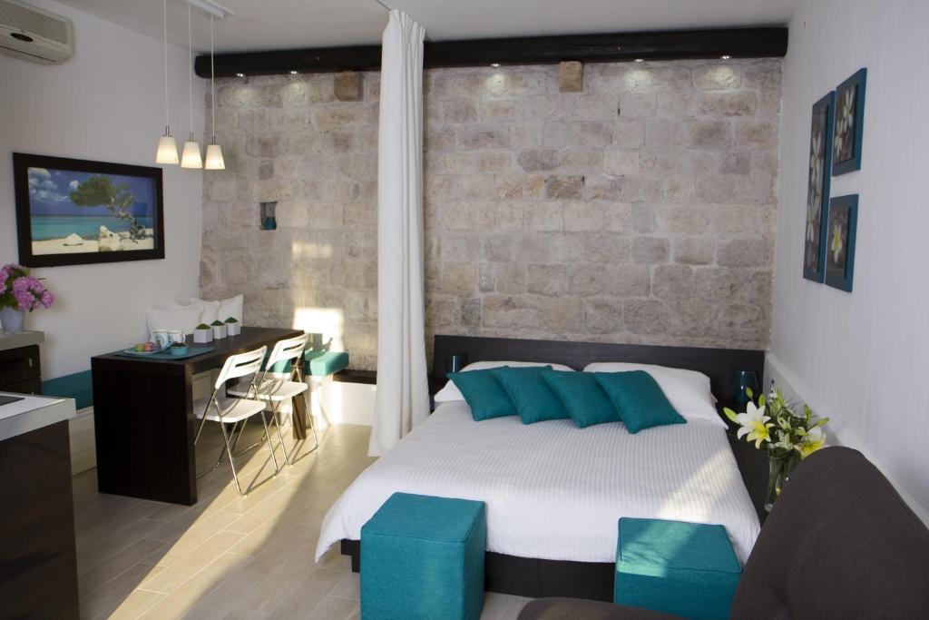 a bedroom with a bed with blue pillows at Studio apartment Malo more in Trogir