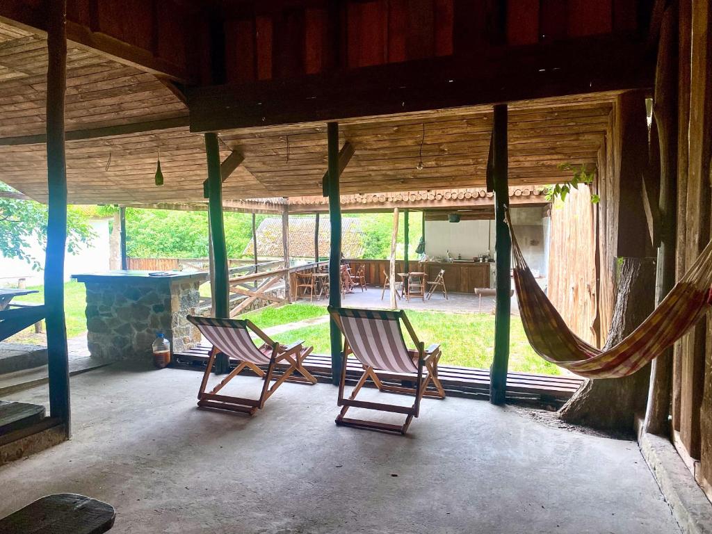 twee schommelstoelen op een veranda met een hangmat bij Bukska Sadyba in Buki