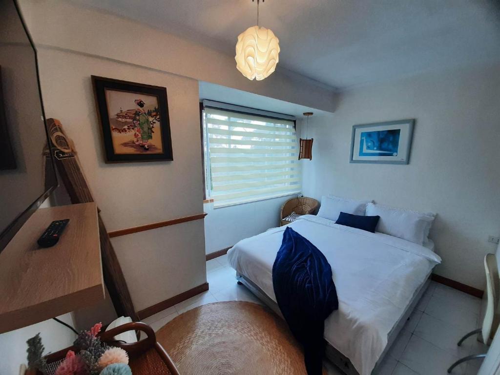 ein kleines Schlafzimmer mit einem Bett und einem Fenster in der Unterkunft Relaxing / Minimalist homestay - 1 Bed & Bath in Camp John Hay