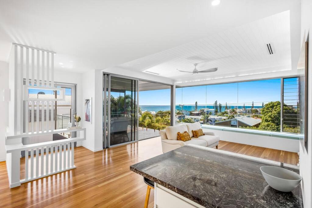 a living room with white walls and a large window at Ocean Blue @ Alex in Alexandra Headland