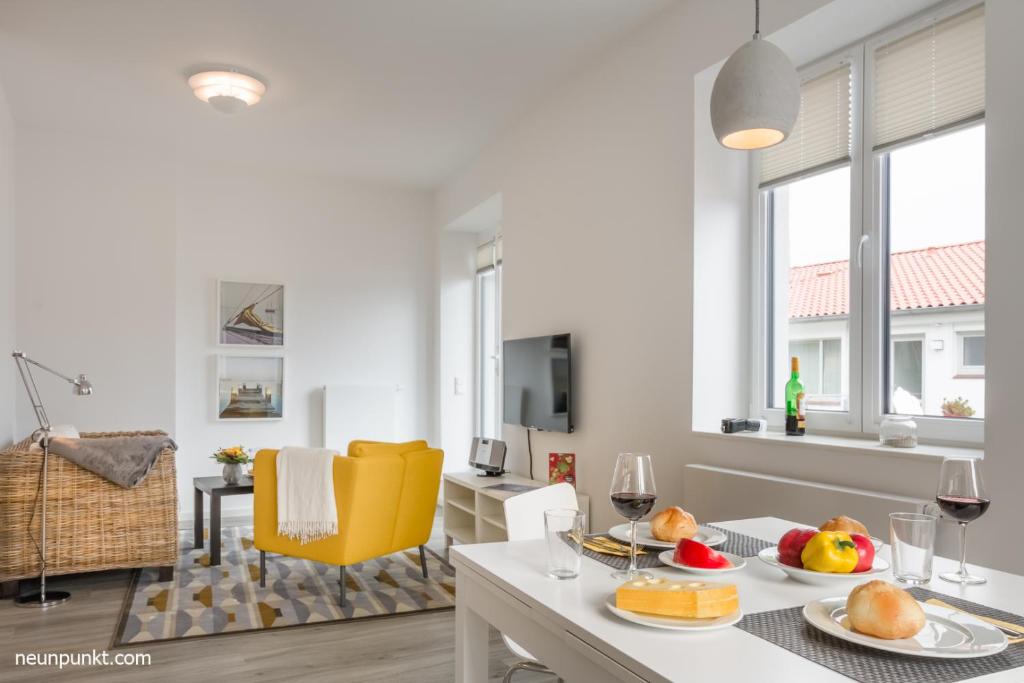 un salon blanc avec une table avec de la nourriture dessus dans l'établissement Heimathafen 2 - M S Küselwind, à Kappeln