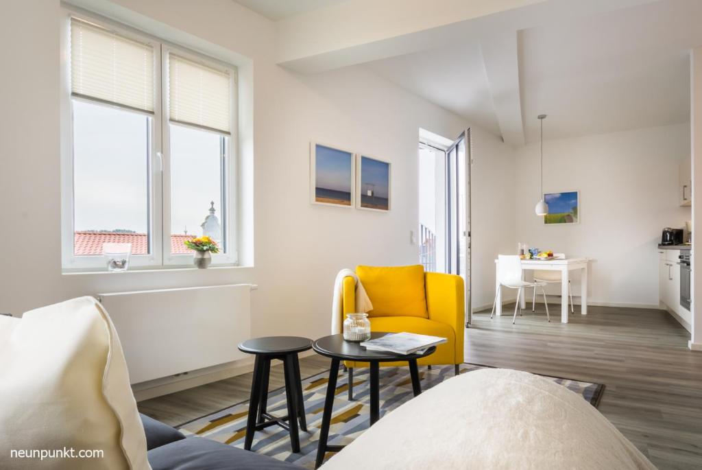 un salon avec une chaise jaune et une table dans l'établissement Heimathafen 3 - M S Atlantis, à Kappeln