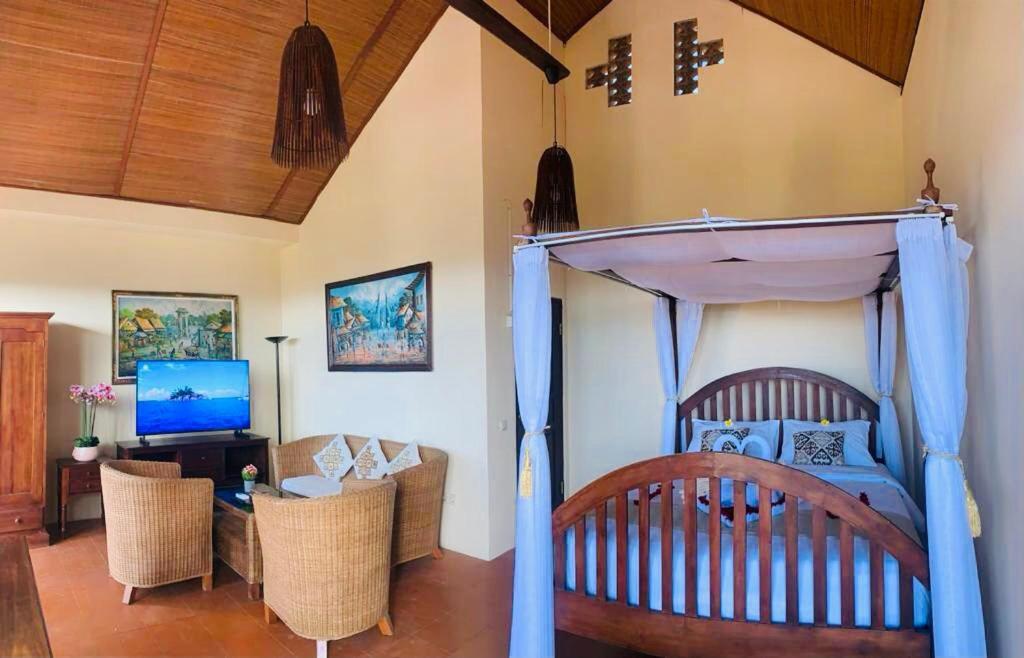 a bedroom with a bed and a living room at Giri's Villa Jimbaran in Ungasan