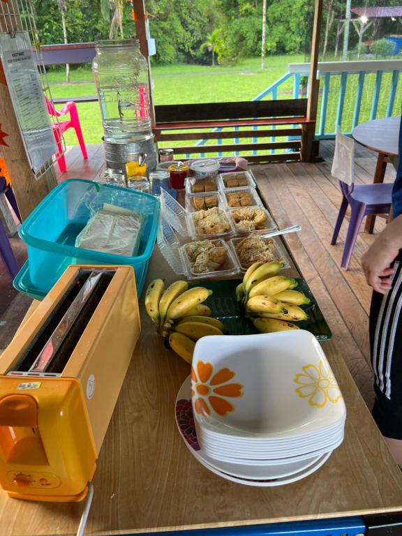 a table with a tray of bananas and a cup at Mulu Village in Mulu