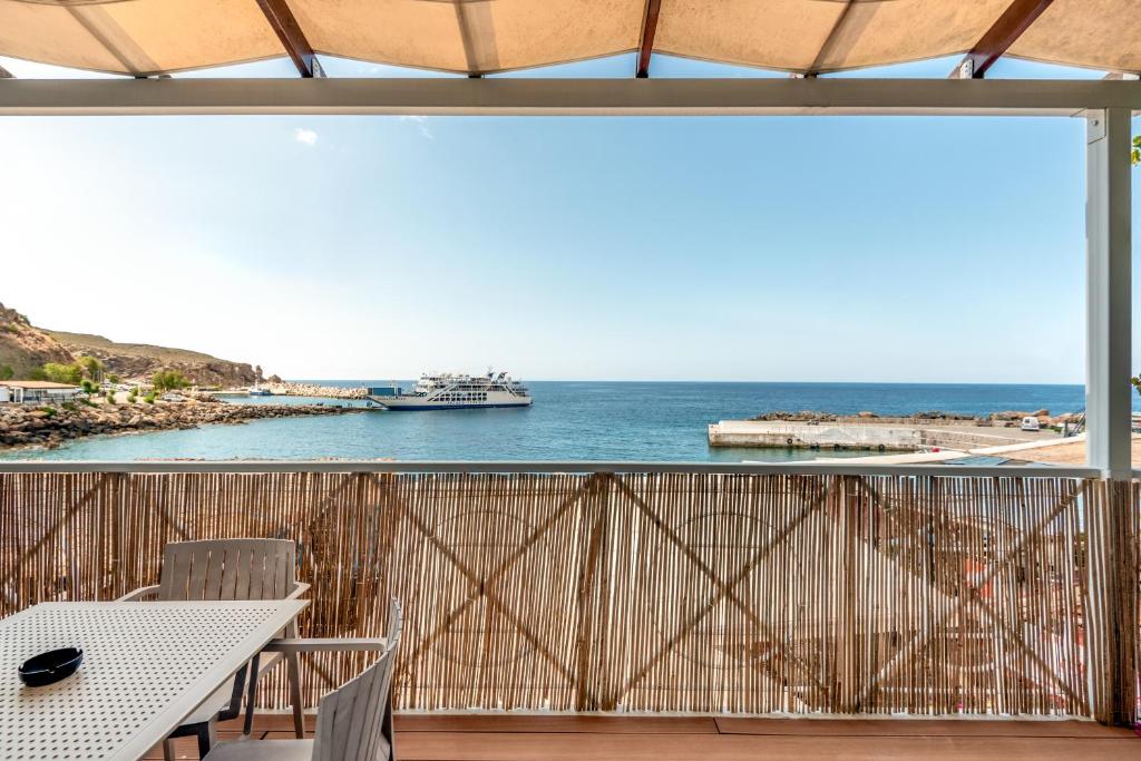 balcón con mesa, sillas y vistas al océano en Superb apartmentS Kriaras sea view in Sfakia, en Chóra Sfakíon