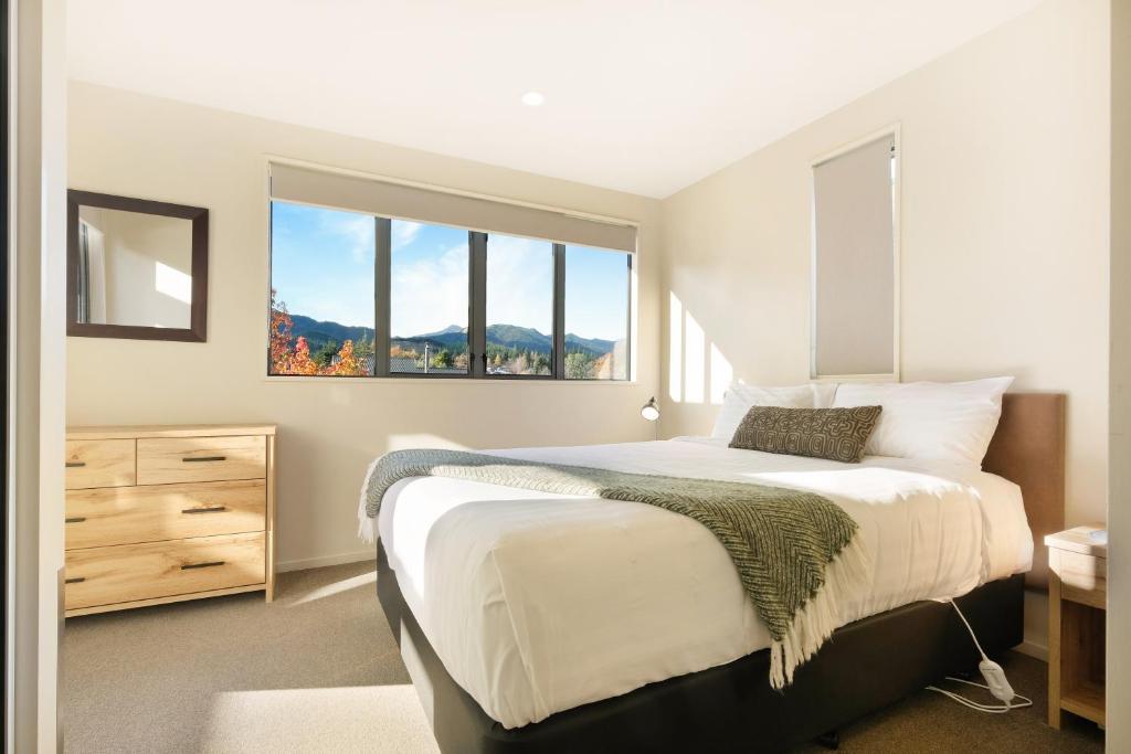 Un dormitorio con una cama grande y una ventana en *** LAKE VILLA 467 *** en Hanmer Springs