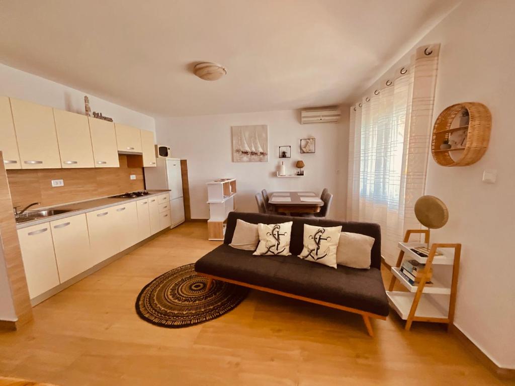 een woonkamer met een bank en een keuken bij Villa Veic in Rogoznica