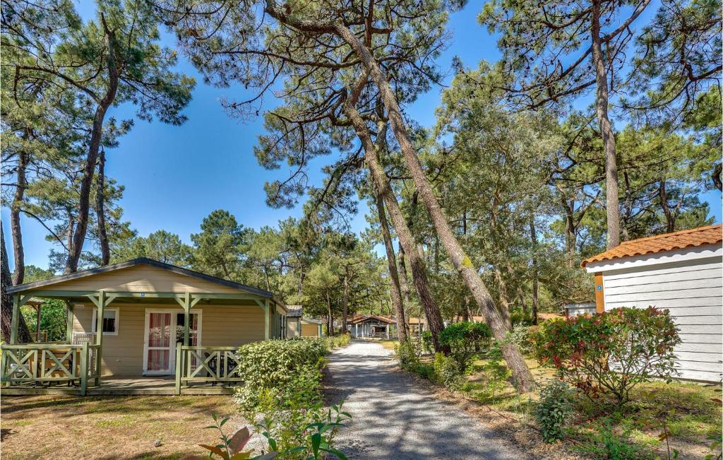 a cottage with a tree leaning over a driveway at 2 Bedroom Beautiful Home In La Faute-sur-mer in La Faute-sur-Mer