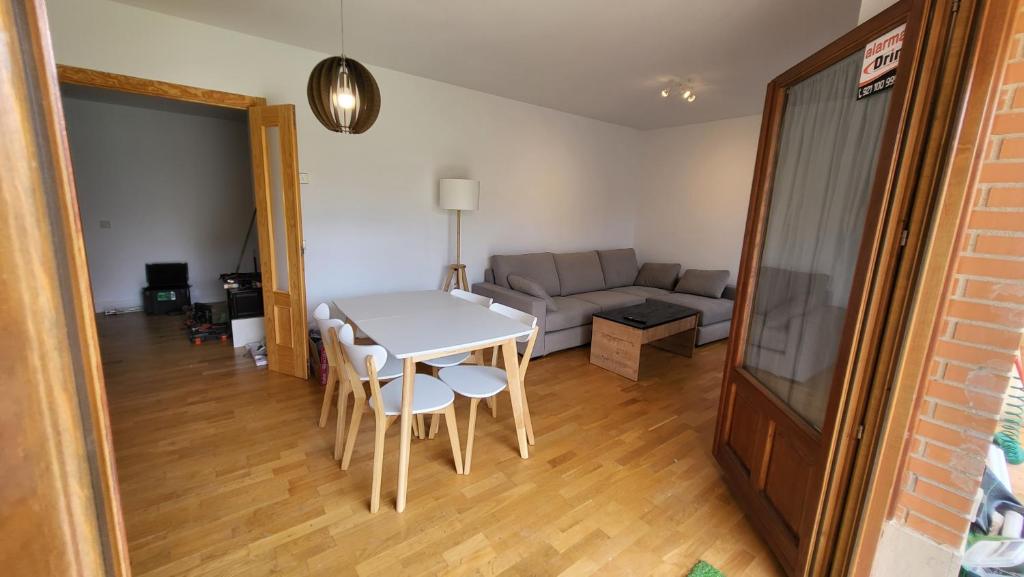 een woonkamer met een tafel en stoelen en een bank bij Las Casitas de Bernuy VUT in Segovia