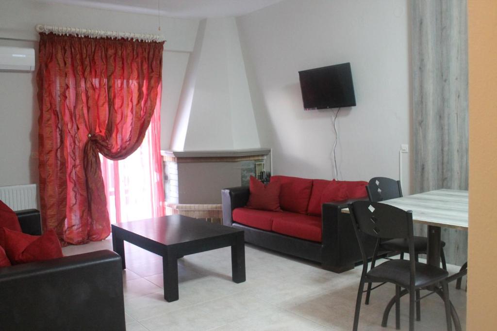 sala de estar con sofá rojo y mesa en Paralia Apartments, en Paralia Katerinis