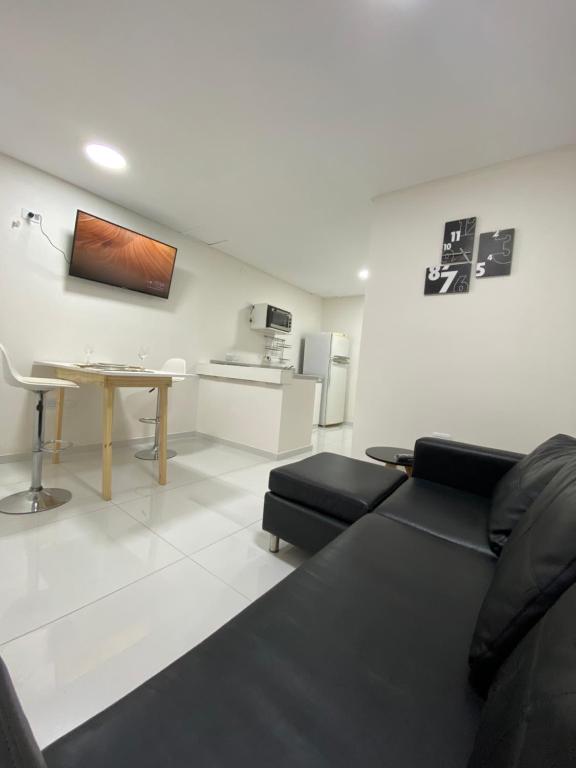ein Wohnzimmer mit einem Sofa und einem Tisch in der Unterkunft Fama Suite YB in La Rinconada