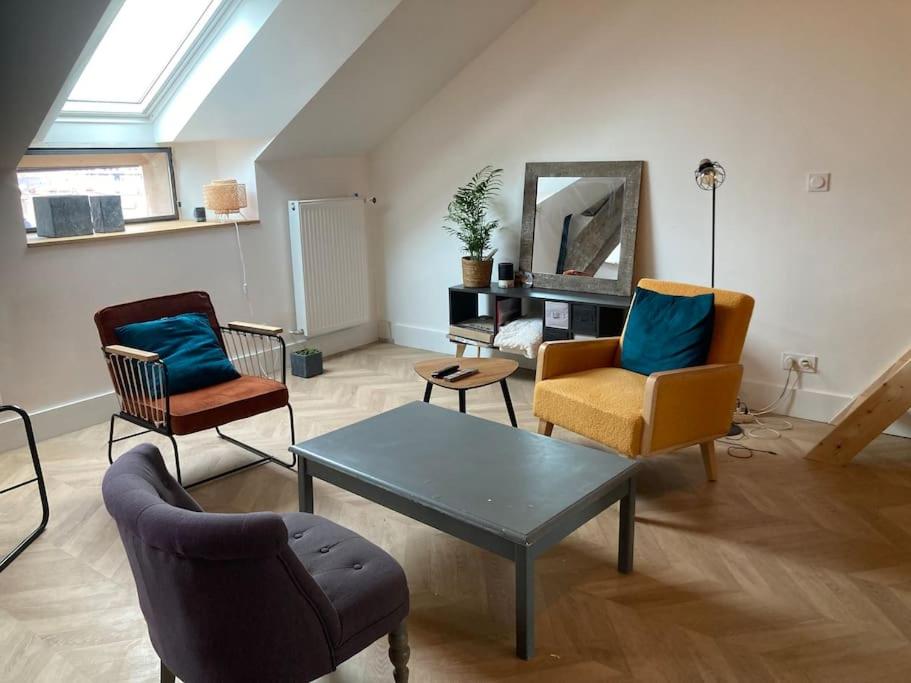 - un salon avec des chaises, une table et un miroir dans l'établissement Atypique Chevreul, à Angers