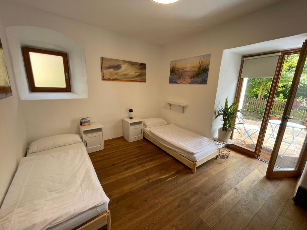 a bedroom with two beds and a balcony at Roomerie im Zentrum in Sulzbach-Rosenberg