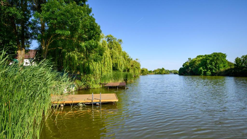 Un río con dos barcos en el medio. en Nándi Vendégház, en Gyomaendrőd