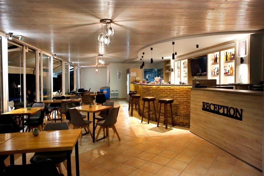 a restaurant with tables and chairs and a bar at Akis Studios Alykes in Alykes