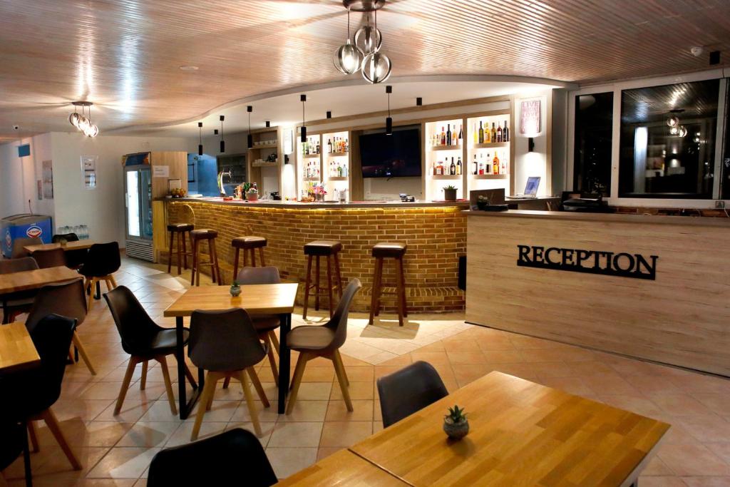 a restaurant with wooden tables and chairs and a bar at Akis Studios Alykes in Alykes