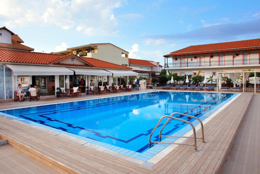 a large swimming pool with blue water in a building at Akis Studios Alykes in Alykes