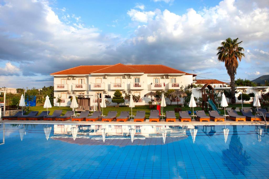 a hotel with a swimming pool with chairs and umbrellas at Akis Studios Alykes in Alykes