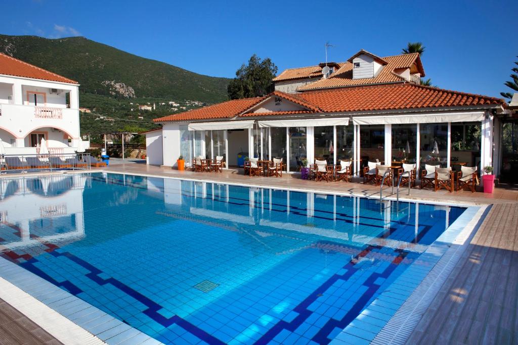 a large swimming pool in front of a building at Akis Studios Alykes in Alykes