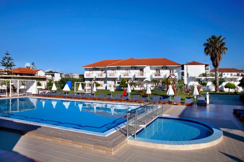a large swimming pool in front of a hotel at Akis Studios Alykes in Alykes