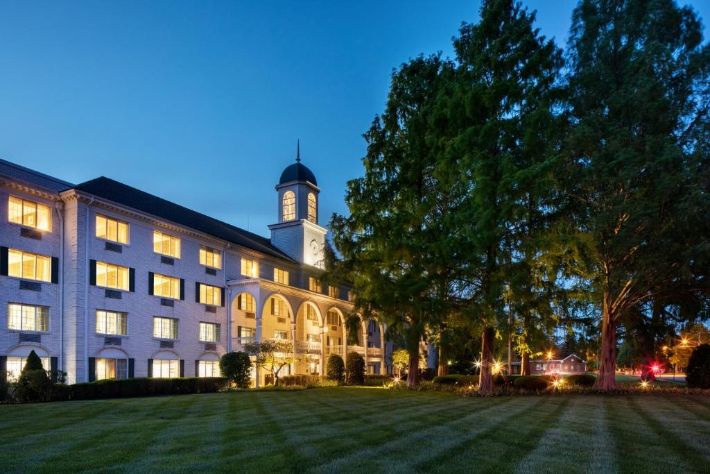 un gran edificio con una torre de reloj por la noche en The Madison Hotel en Morristown