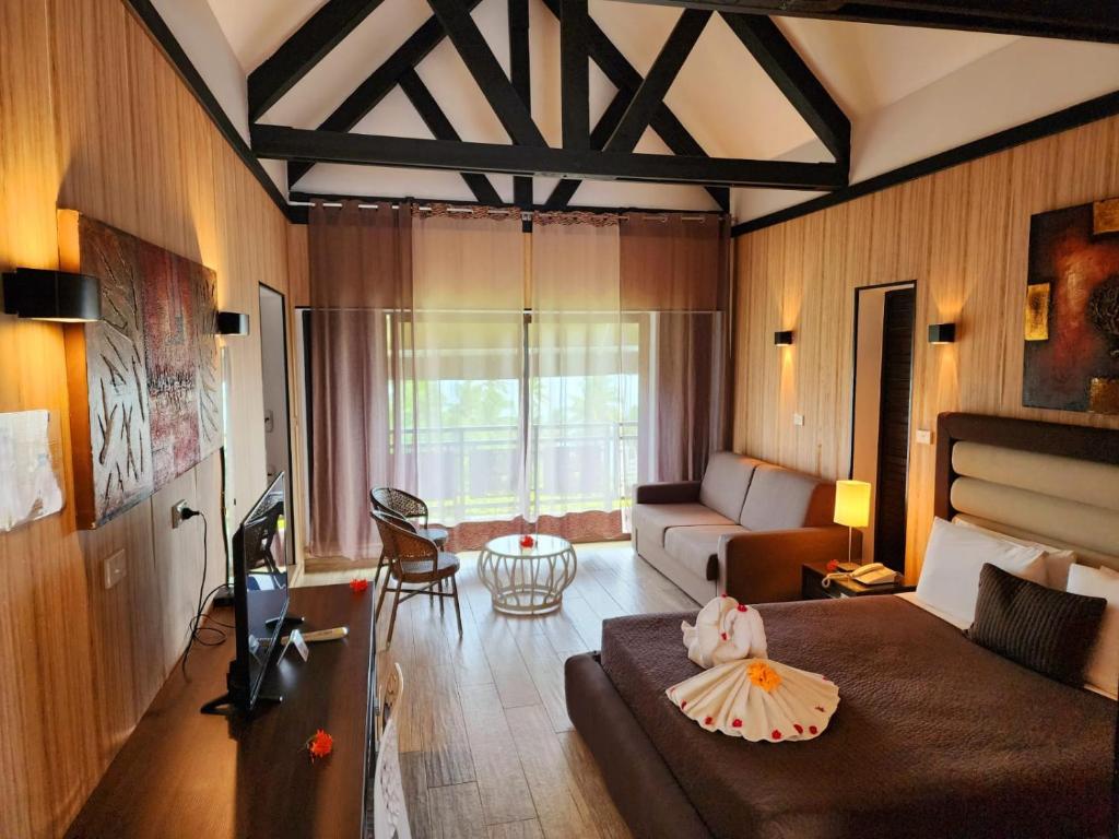 ein Wohnzimmer mit einem Bett und einem Sofa in der Unterkunft The Crow's Nest Resort Fiji in Korotogo