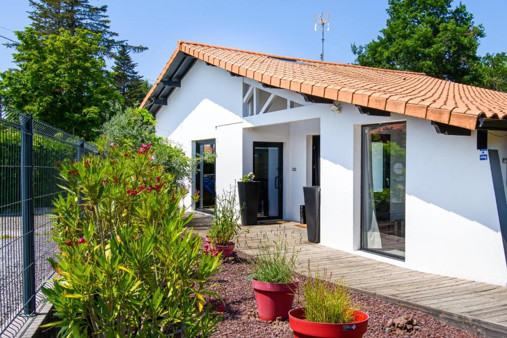 una pequeña casa blanca con plantas en un patio en Landescape Océan, Lacs et Forêt. en Biscarrosse