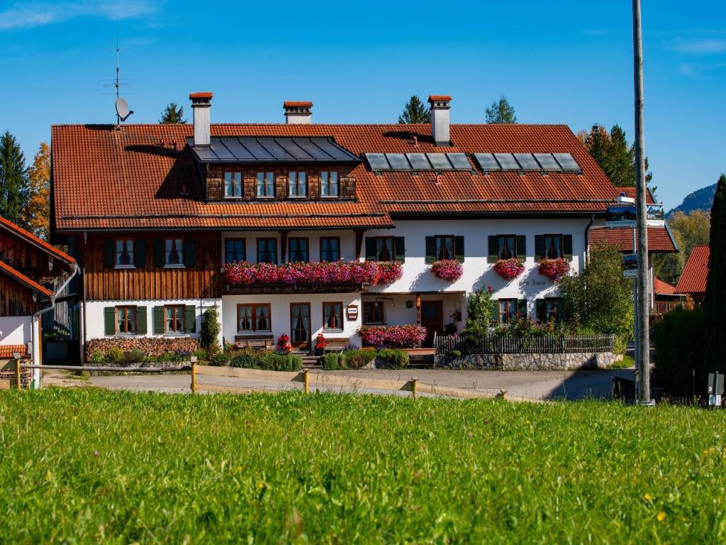 un grand bâtiment avec un toit rouge dans l'établissement Landhaus Beim Joaser, à Schwangau