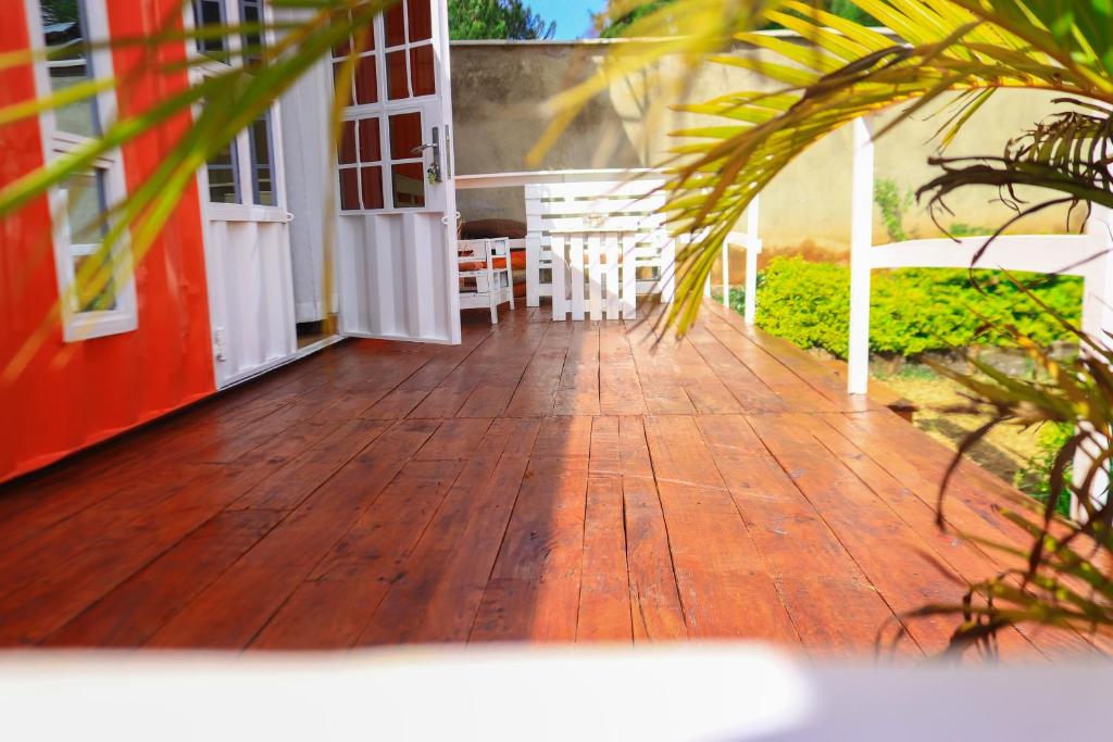 a porch of a house with a wooden deck at The Red Container-Off Grid in Ngong