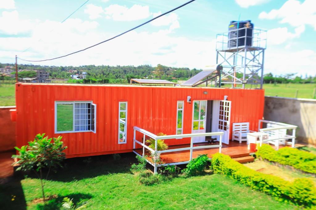 a red tiny house sitting on top of a yard at The Red Container-Off Grid in Ngong