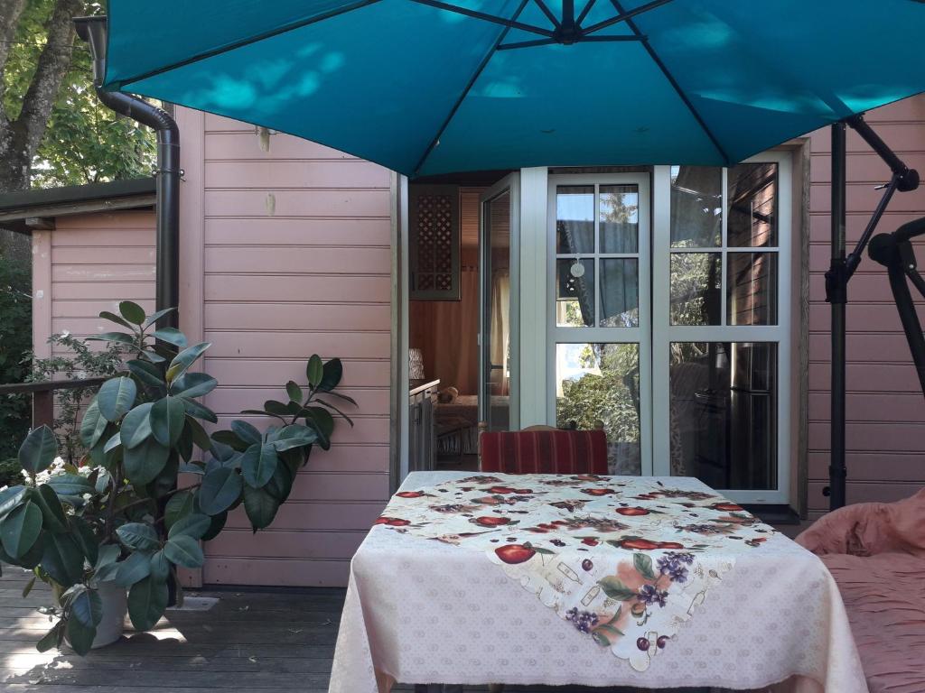 uma casa roxa com uma mesa com um guarda-chuva azul em Apartament Olivija em Jūrmala