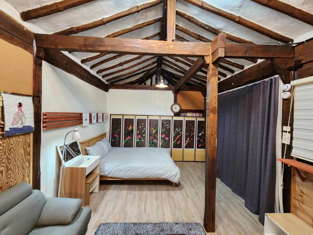 ein Schlafzimmer mit einem Bett und einem Sofa in einem Zimmer in der Unterkunft Kims House Andong in Andong