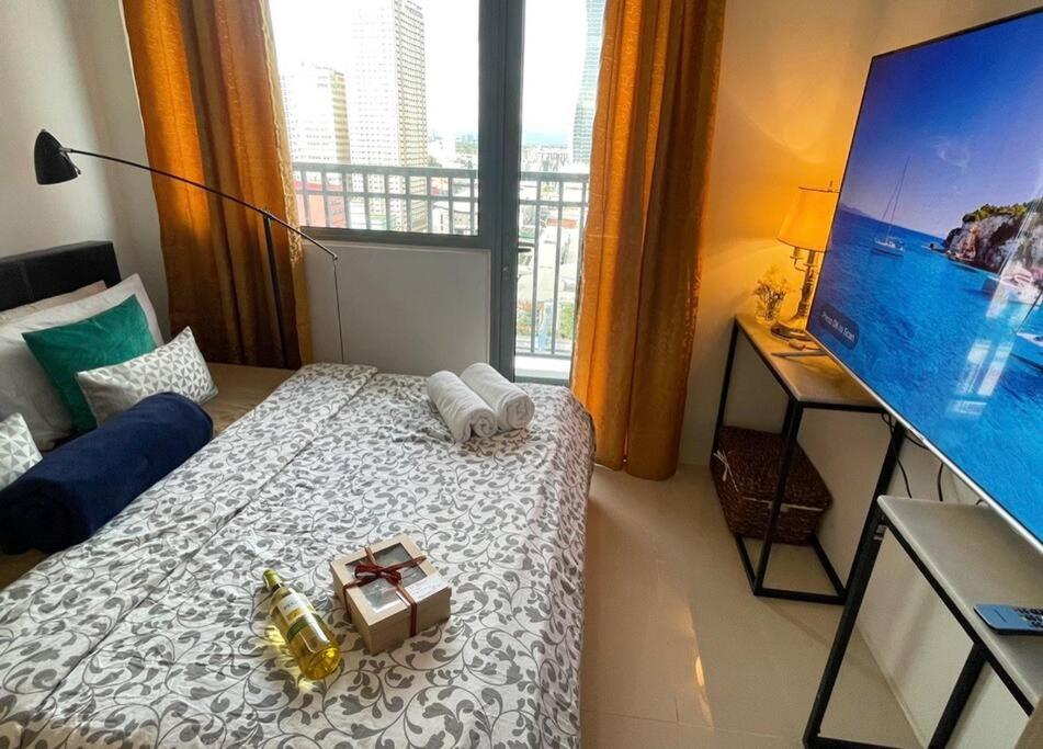 a hotel room with a bed and a large window at Beautiful 1BR balcony w/65UHDTV Wifi Netflix, pool in Manila