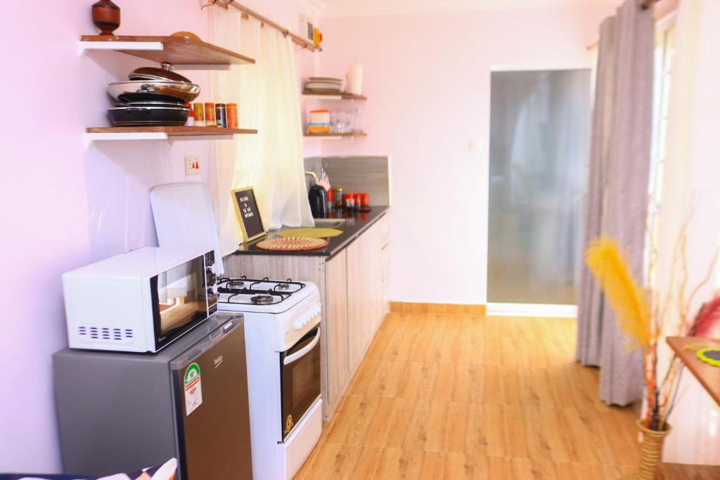 a small kitchen with a stove and a microwave at The Red Container-Off Grid in Ngong