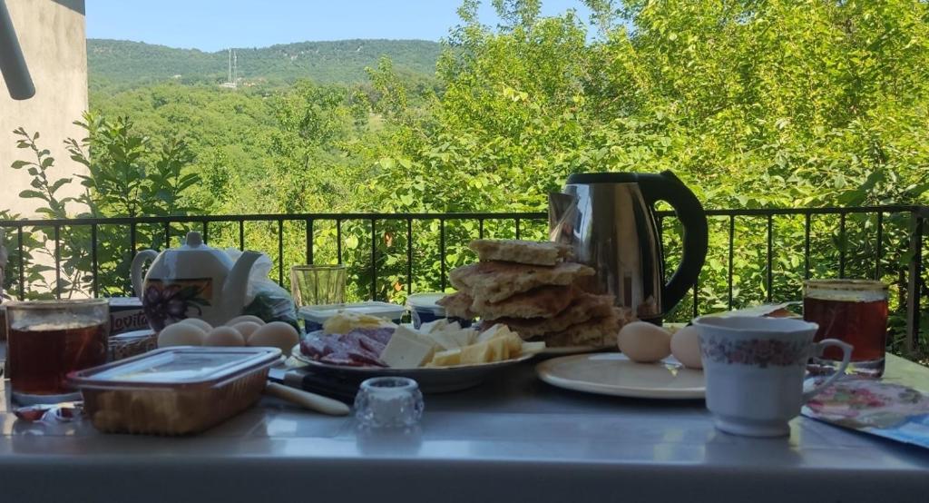 a table with a breakfast of eggs and bread at House by the river in Qǝçrǝş