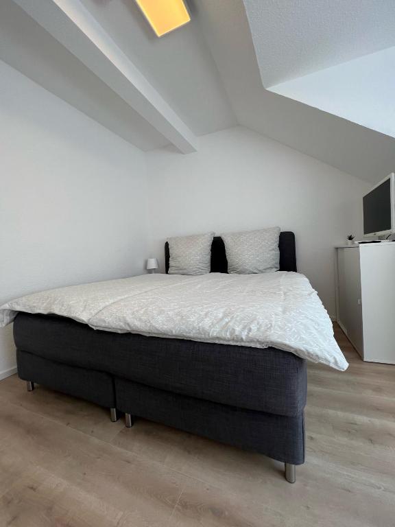 1 dormitorio con 1 cama en una habitación blanca en Modernes Apartment in Bad Kreuznach mit einfachem Self-Check-in, en Bad Kreuznach