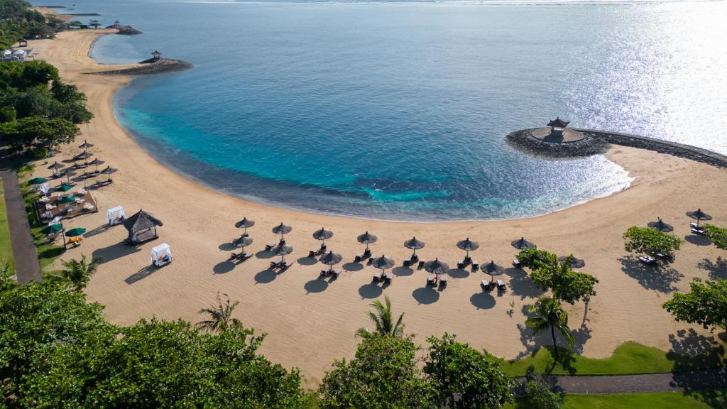 an aerial view of a beach with umbrellas and the ocean at Bali Tropic Resort & Spa - CHSE Certified in Nusa Dua