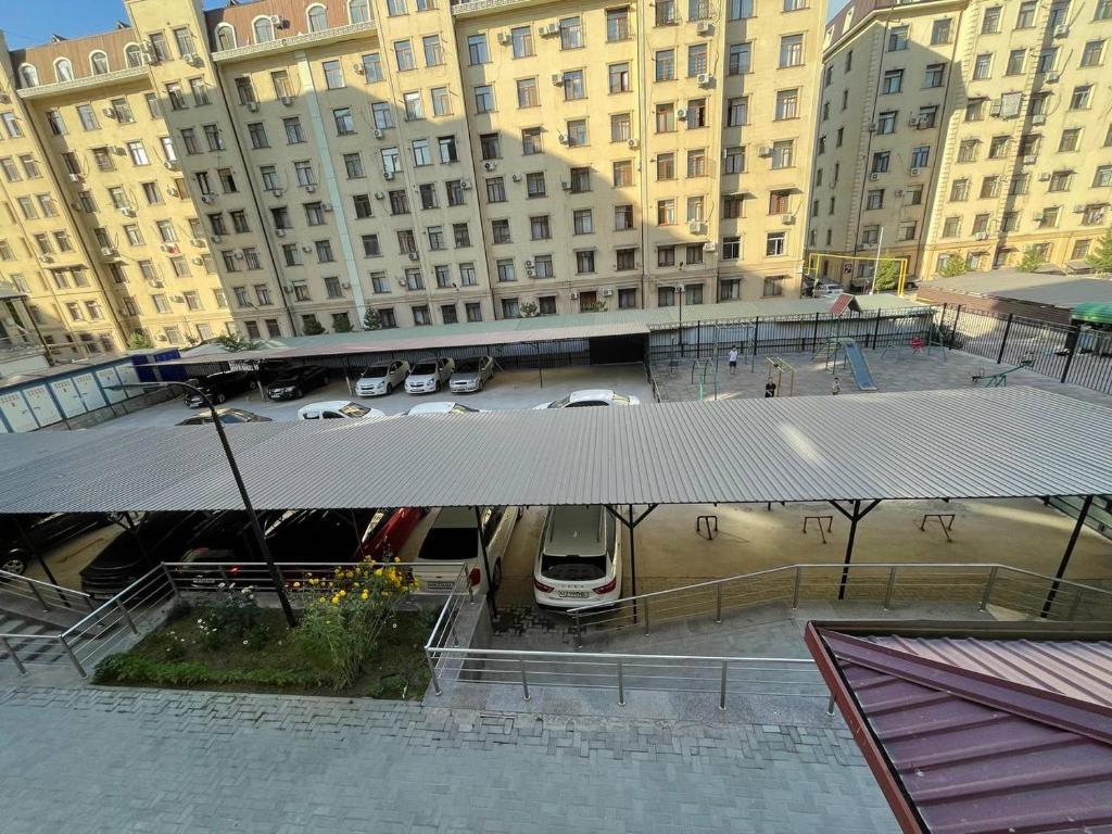 a van parked in a parking lot next to tall buildings at Three bedroom apartment with 2 showers in Tashkent