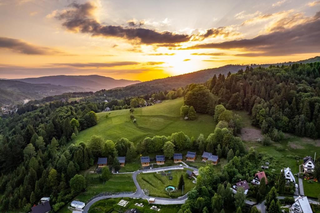 una vista aérea de un complejo en las montañas con la puesta de sol en Domki pod Jaworem Brenna, en Brenna