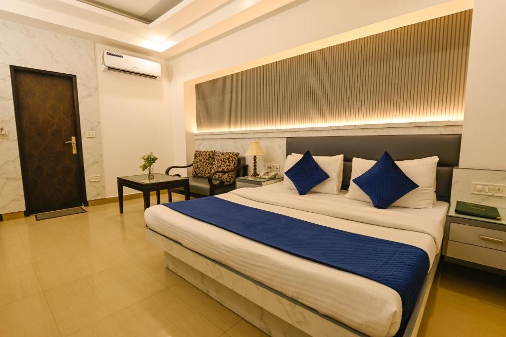 - une chambre avec un grand lit et des oreillers bleus dans l'établissement Hotel Krishna Deluxe-By RCG Hotels, à New Delhi