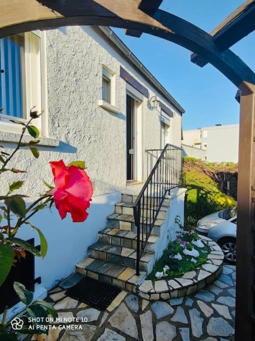 une maison avec un escalier avec une fleur rouge dans l'établissement chez Natalie et Serge, à Lannion