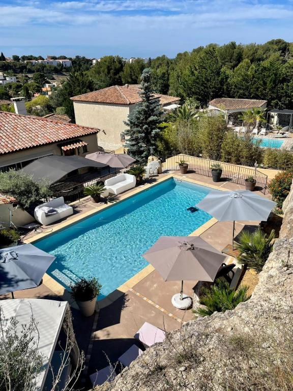 une image d'une piscine avec parasols dans l'établissement Villa fiora classée 4 étoiles, à Martigues