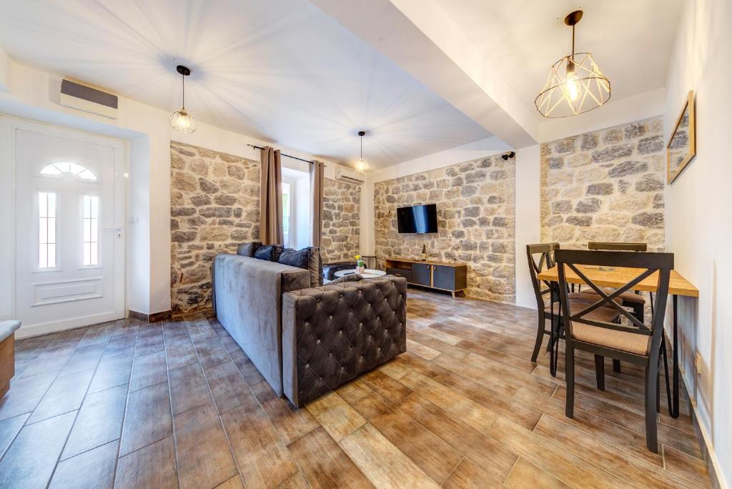 ein Wohnzimmer mit einem Tisch und einem Sofa in der Unterkunft Happy Home Apartments in Kotor
