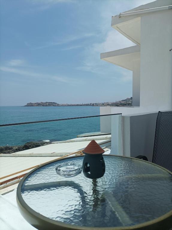 un uccello con un cappello seduto sopra un tavolo di Beachfront apartment a Rethymno