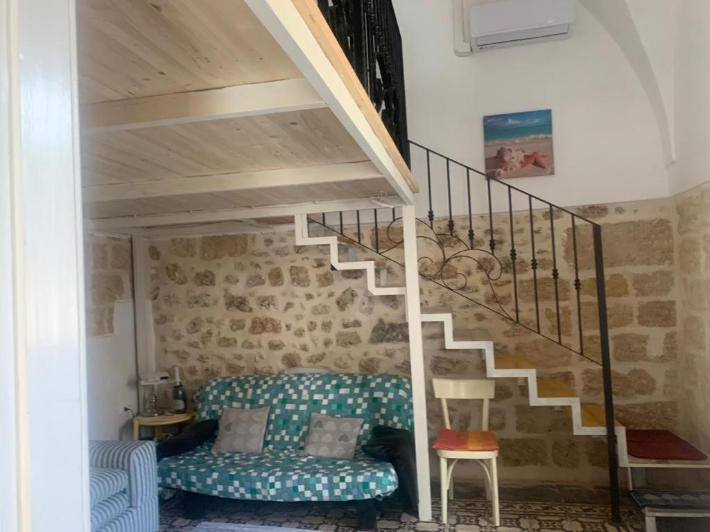 uma sala de estar com uma escada e um sofá em Casa Contadina em Giuliano