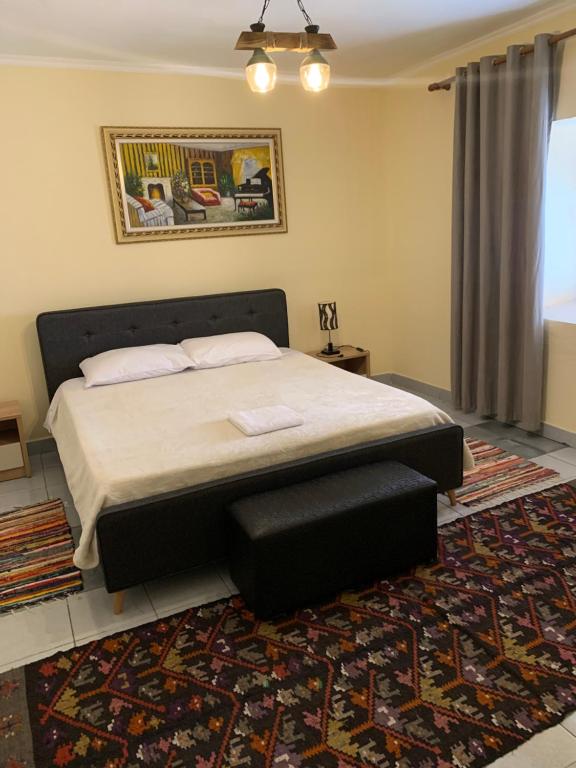 a bedroom with a large bed and a rug at Tradicional Bazaar Home in Korçë