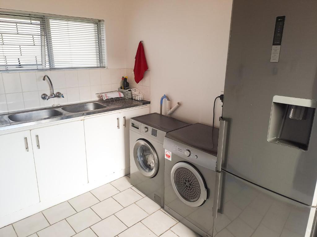 a kitchen with a washing machine and a sink at Franskraal cosy 3 bedroom in Franskraalstrand