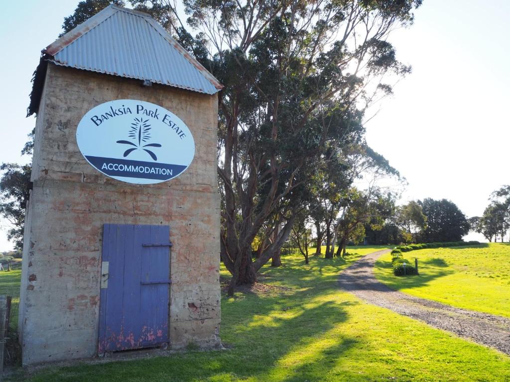 a brick building with a blue door and a sign at Banksia Park Estate in Phillip Island