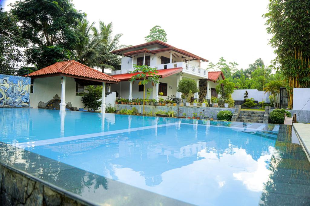 a swimming pool in front of a house at Villana Villa Bentota in Bentota